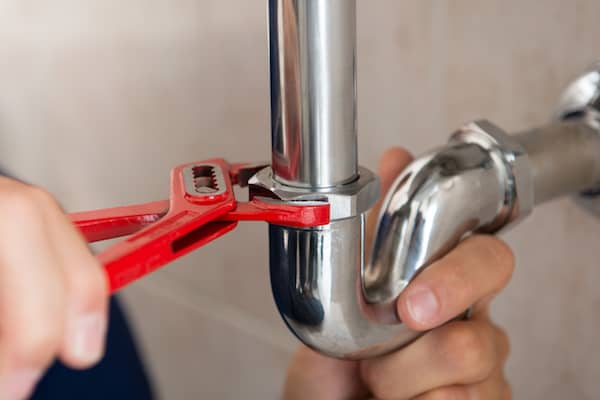 Closeup,Of,Plumber,Fixing,Pipe,With,Wrench